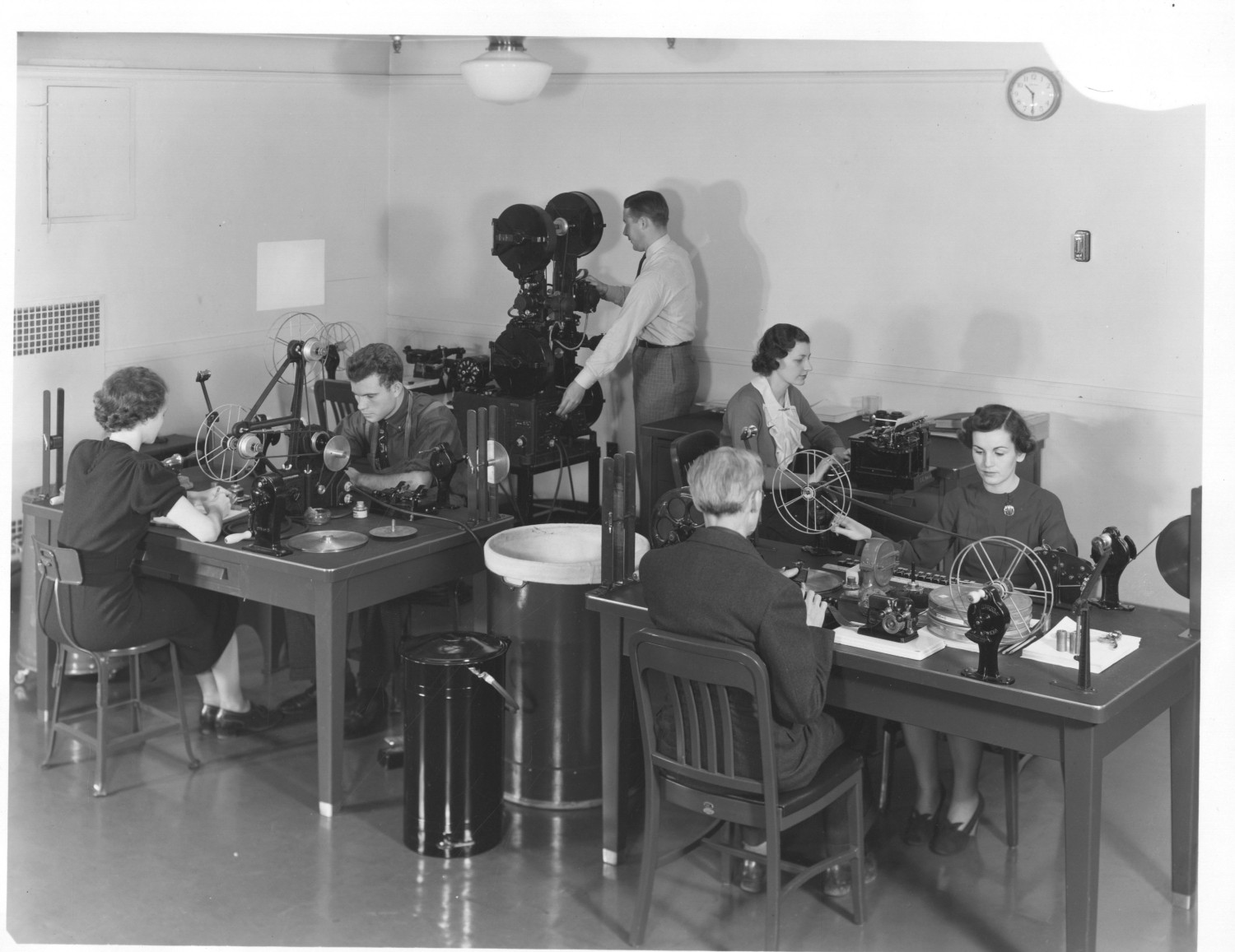 This event poster shows a black and white photograph of several people working in a film archive.