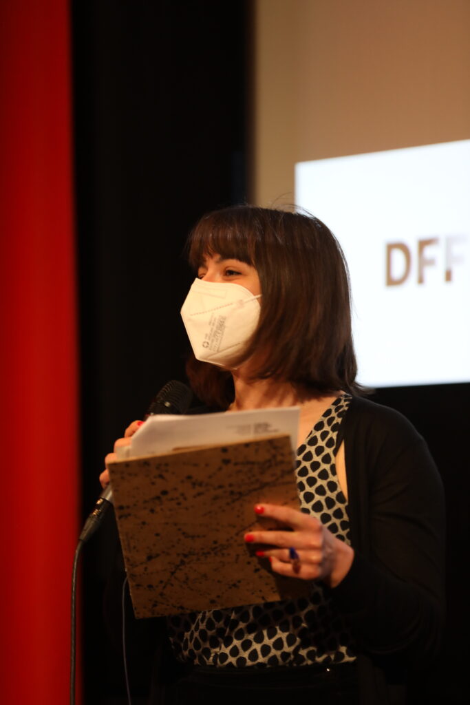 This photo shows a woman talking into a microphone.