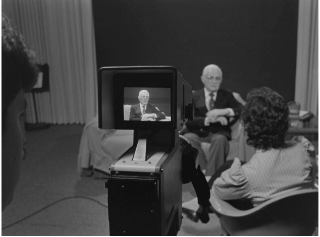 This event poster shows a photograph of a video interview with a Holocaust survivor